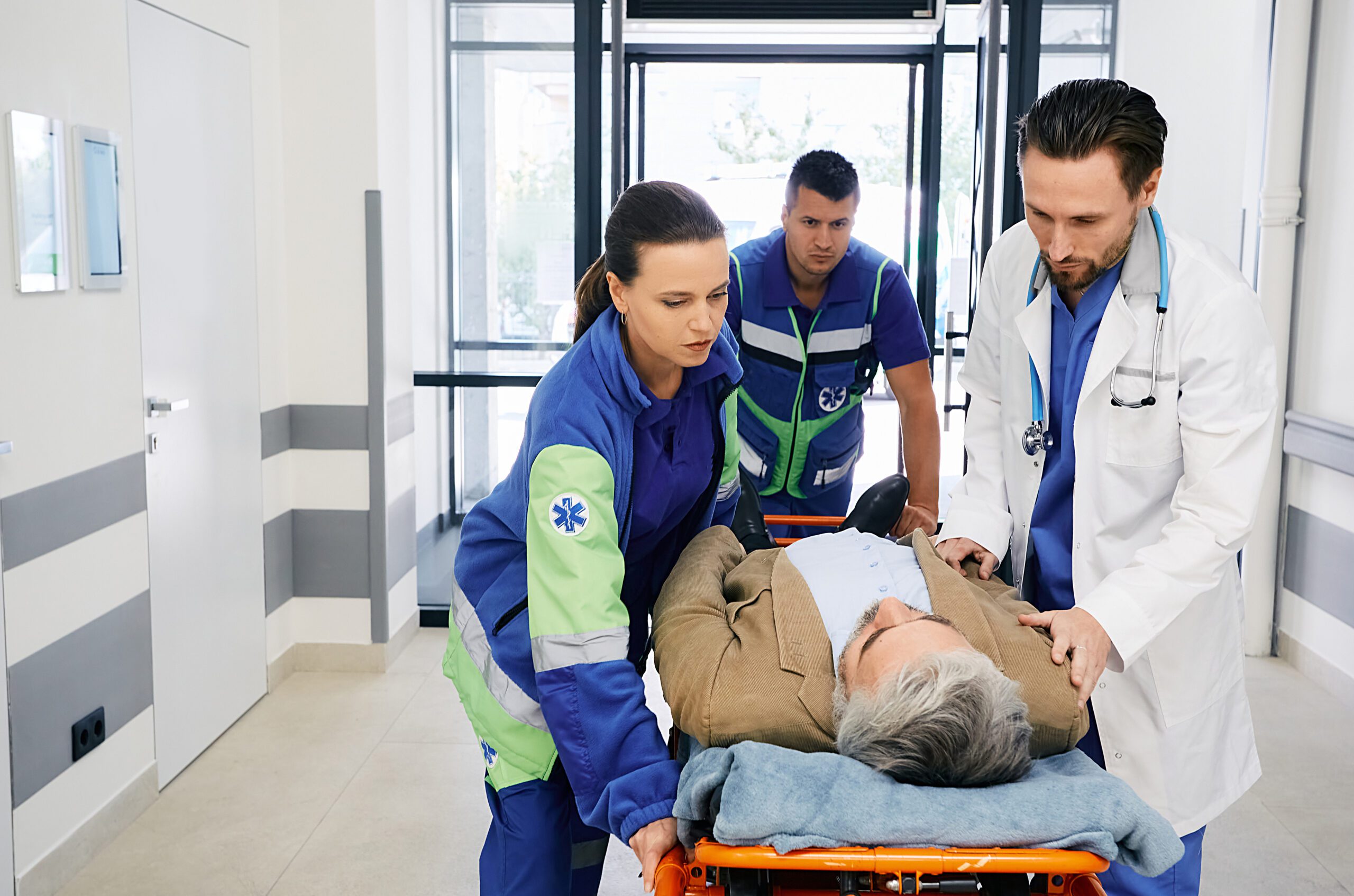 Paramedics and doctor rushing with victim patient on ambulance stretcher on hospital corridor at emergency department. Emergency medical services Studiengang "Digitales Rettungsmanagement" 2023